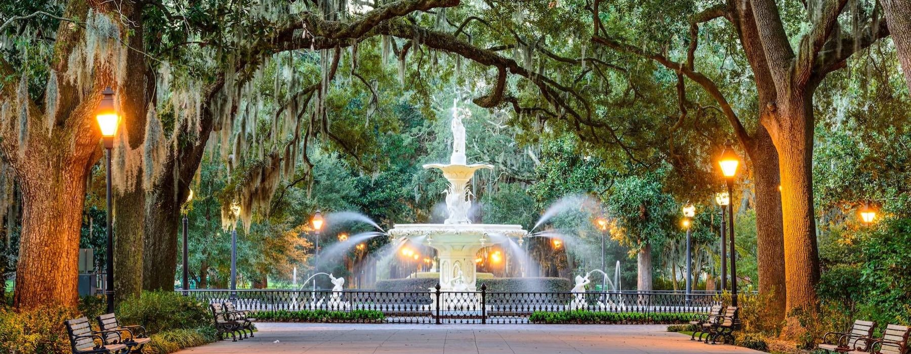 a water fountain with trees overtop
