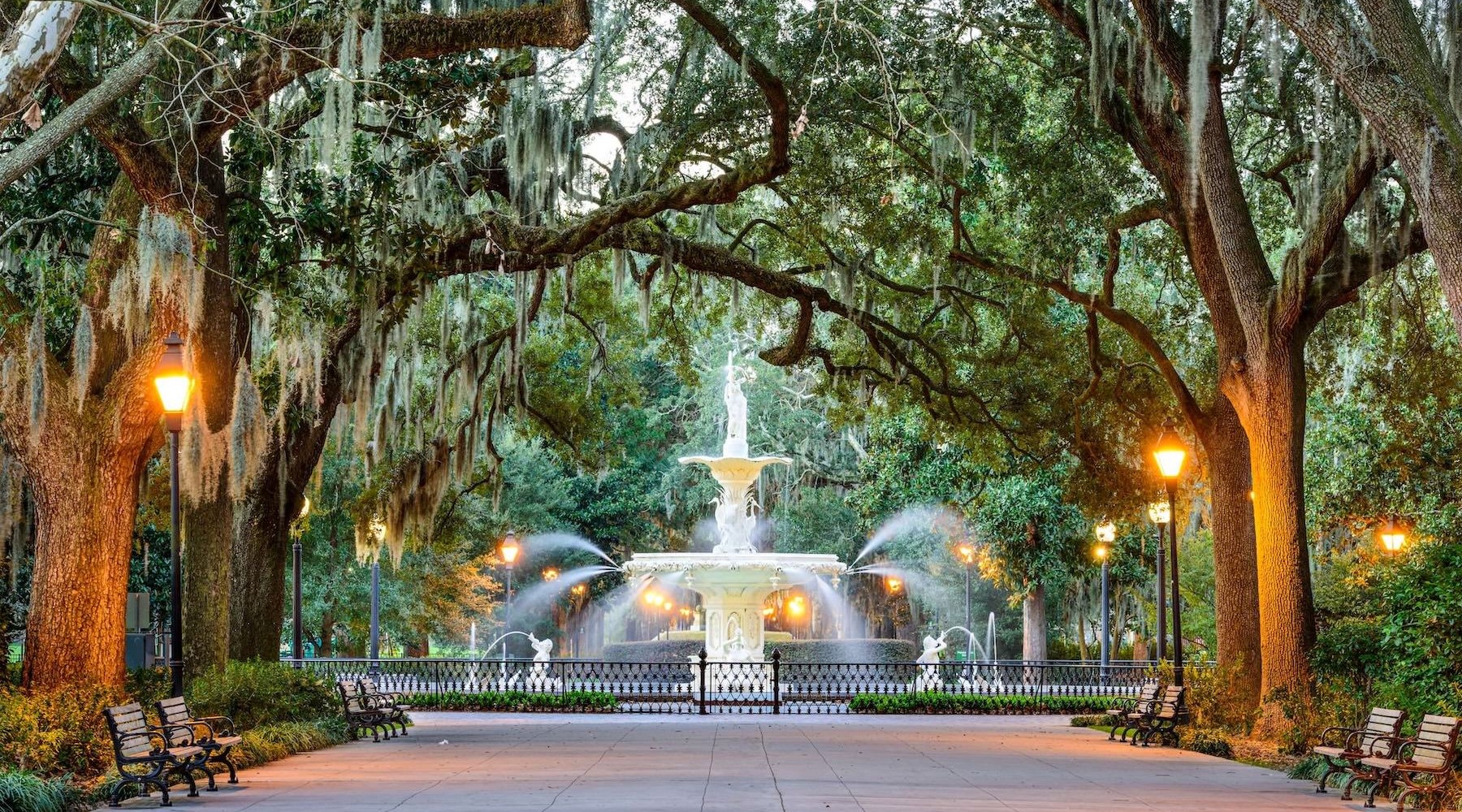 a water fountain with trees overtop