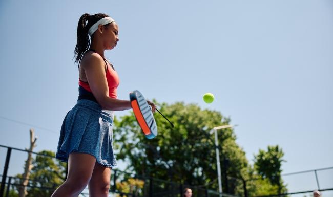 a woman hitting a ball with a tennis racket