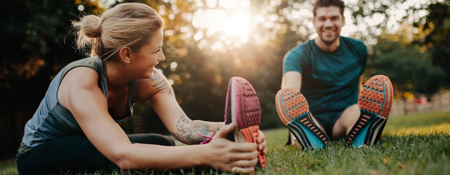 people stretching in a park at sunset